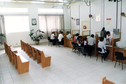 Sala com mesas de atendimento e bancos de espera